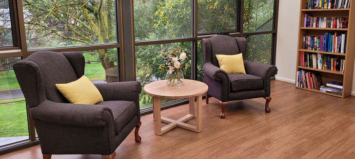 Sitting room with large windows filled with greenery