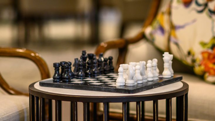 Close up of a chess board on a side table, set up ready to play