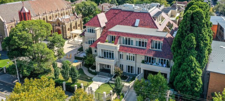 Overhead view of a multi story ecru coloured building with red shingled roof