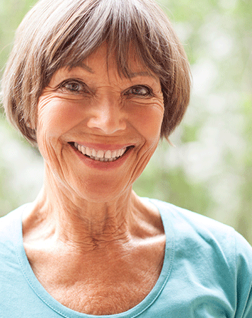 Woman smiles to camera showing teeth