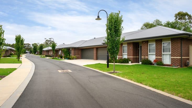 Brown brick houses with dark grey garages, lamppost in front yard