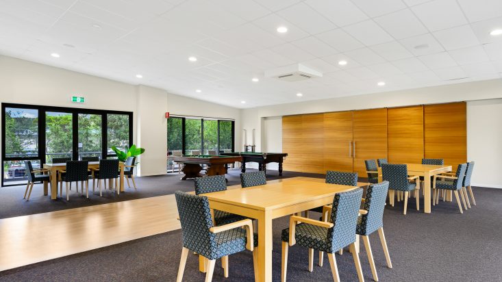 Dining sets with wooden tables and blue patterned chairs, pool tables and wooden sliding doors behind