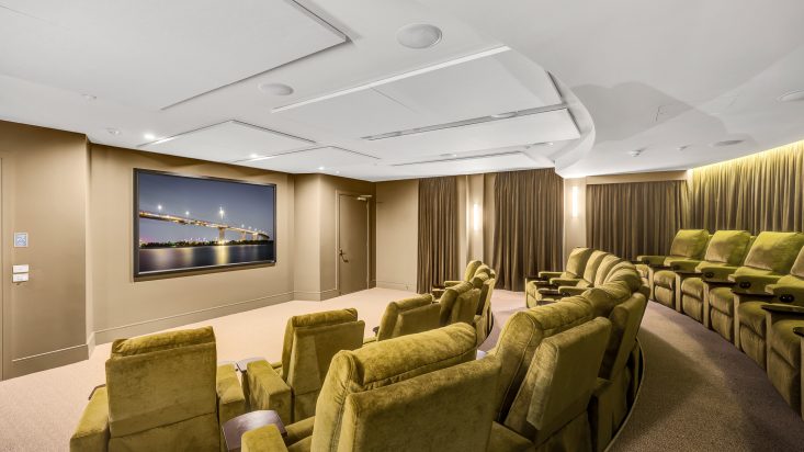 Cinema with beige wall and tiered yellow-green velvet seats