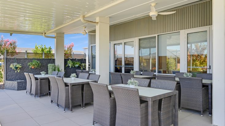 Grey outdoor dining sets sit under a pergola