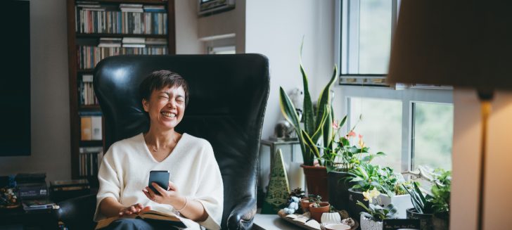 Senior Asian woman using smartphone to communicate with her friends at home