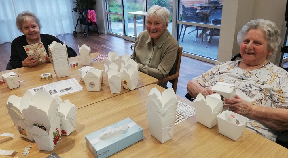 Three woman making gifts for the Christmas hampers