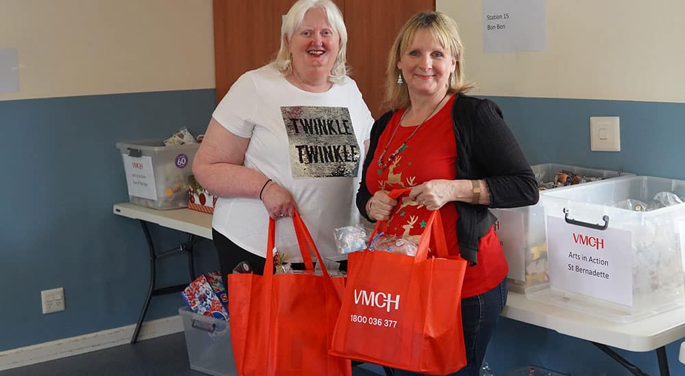 Two women holding Christmas Hampers and smiling