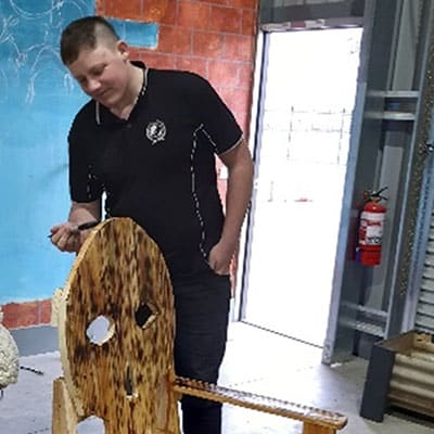 Young man painting a chair