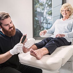 Woman receiving a pedicure from a nurse