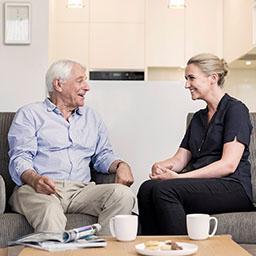 Woman and older man having a conversation over tea