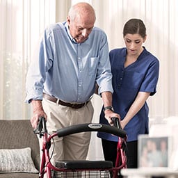 Nurse helping man with his walker