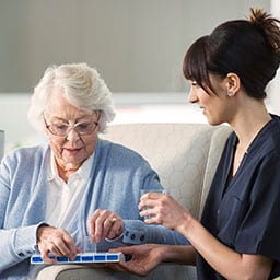 Nurse handing older woman her medication