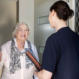 Woman talking to other woman at the front door