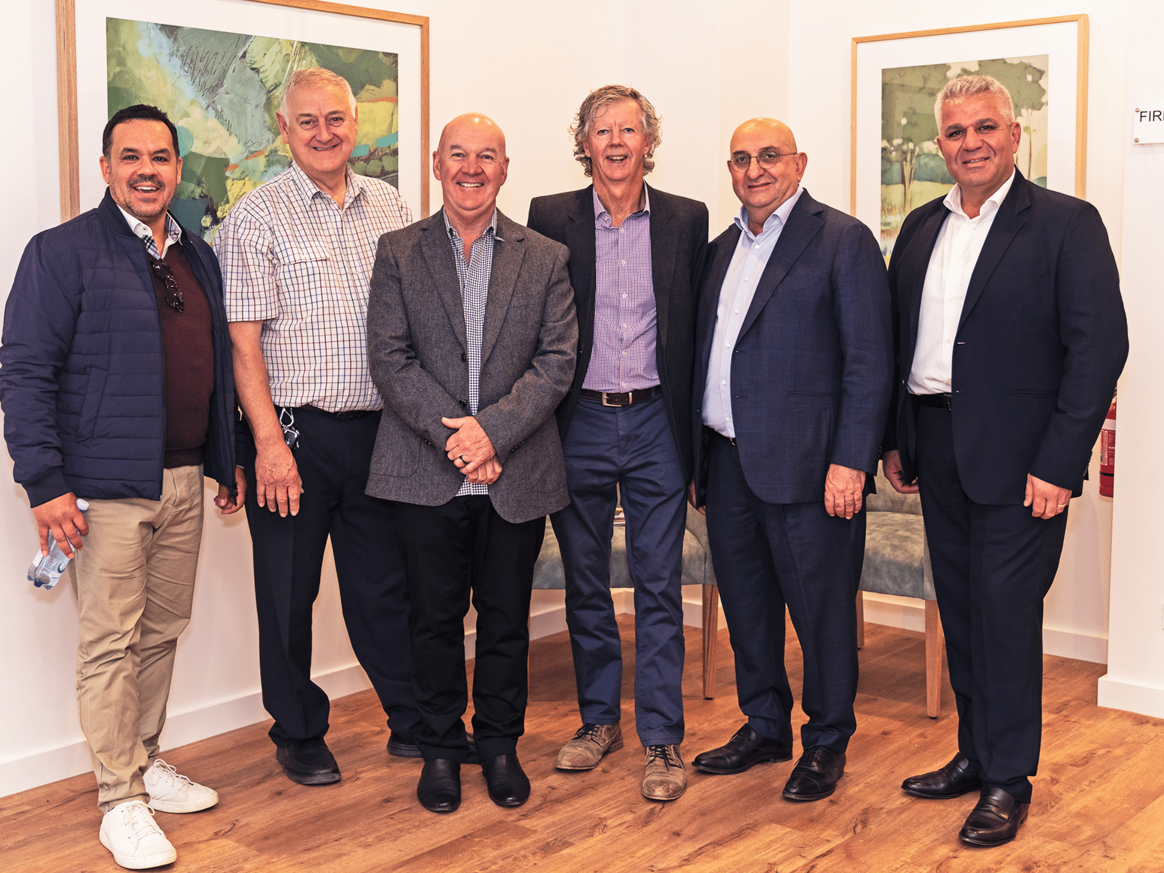 Six men standing in a foyer