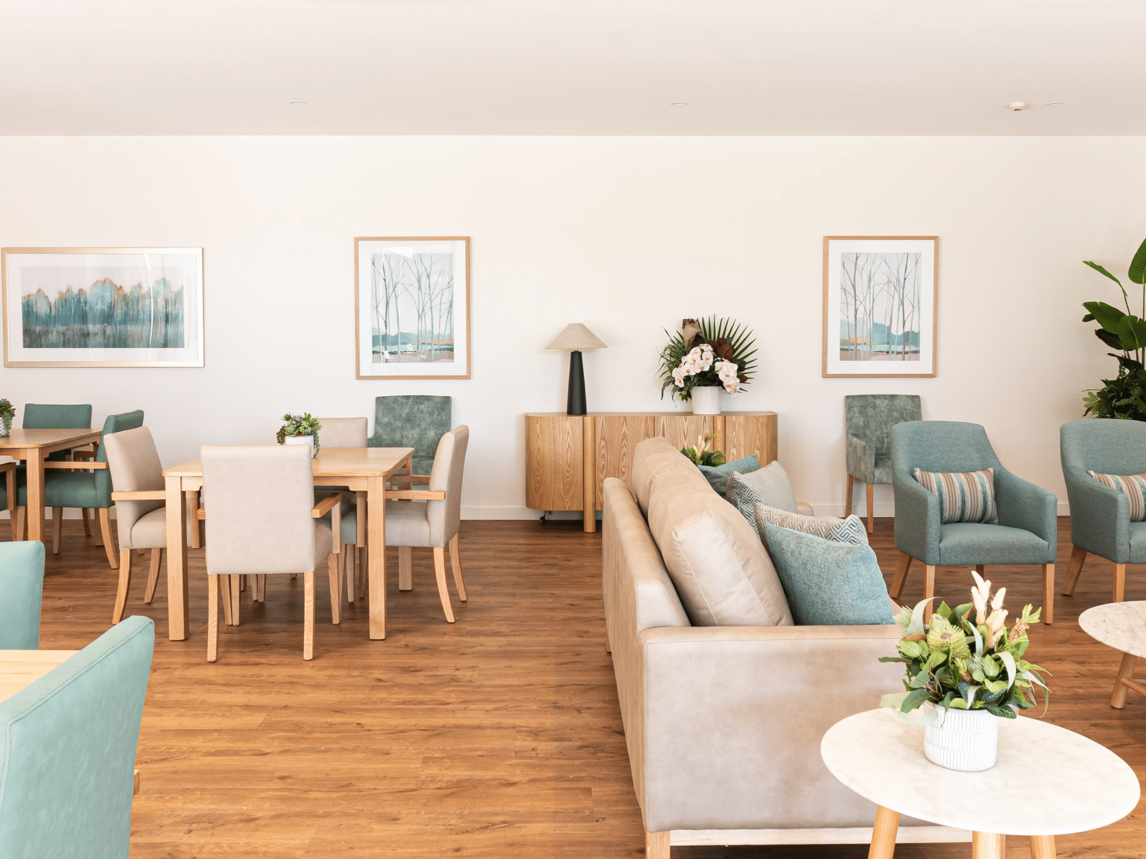 A loung room with sideboard, couches, chairs and tables