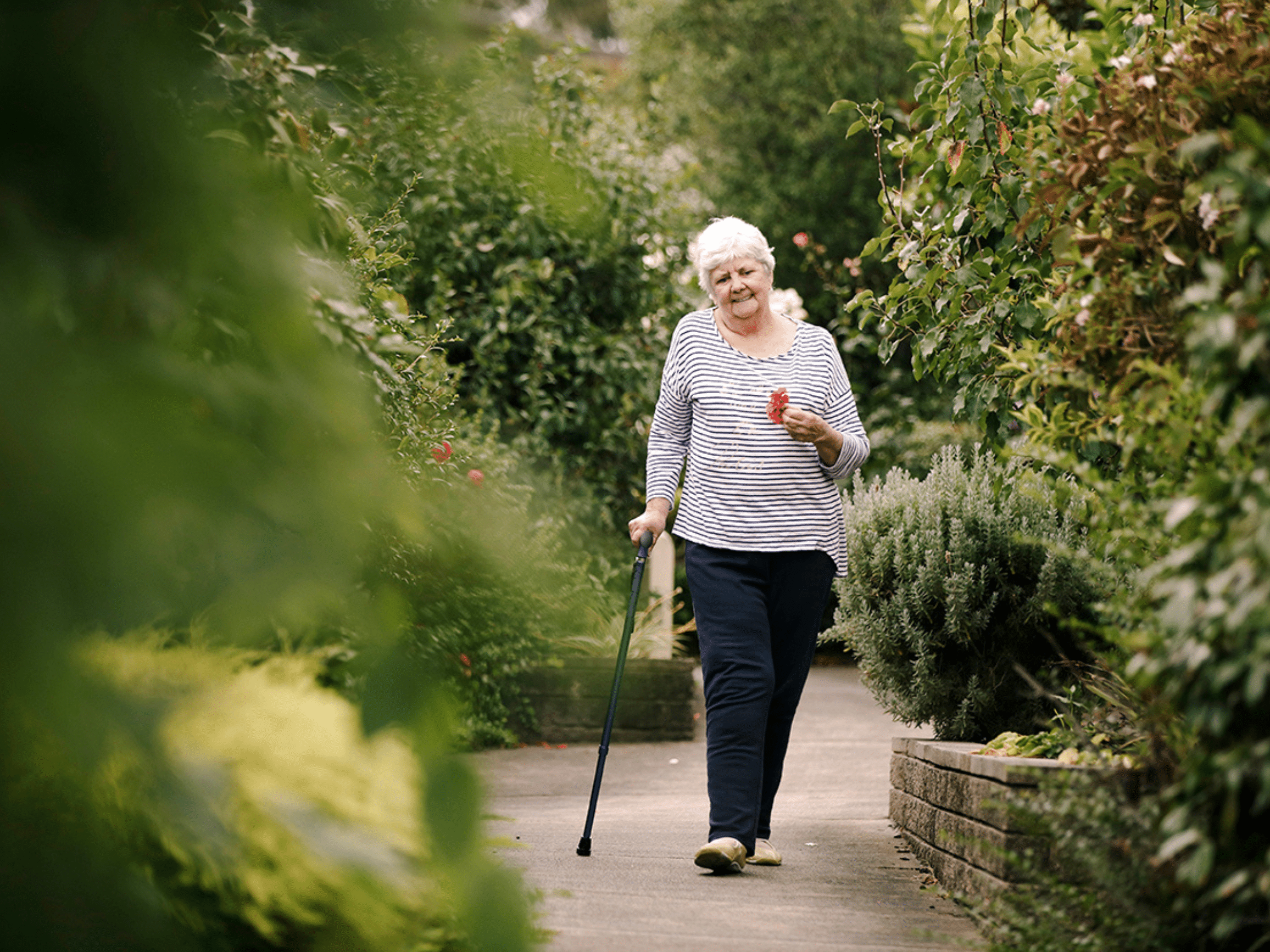 An older woman walks with a cane