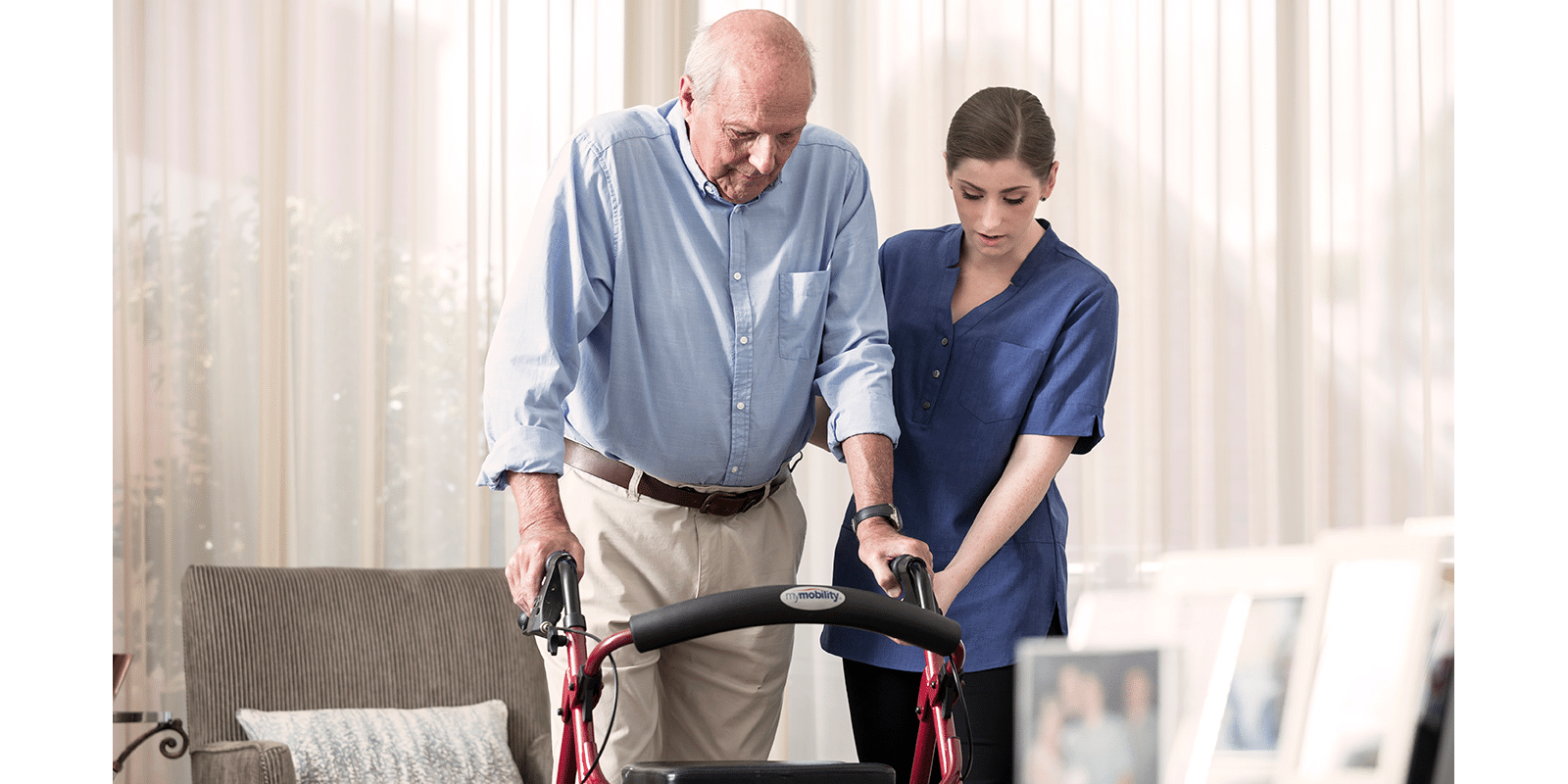 A man being helped to use his walker by his carer