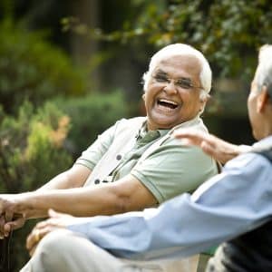 Two senior men chatting on park bench