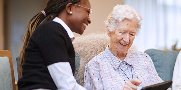 A staff member laughing with an female aged care resident