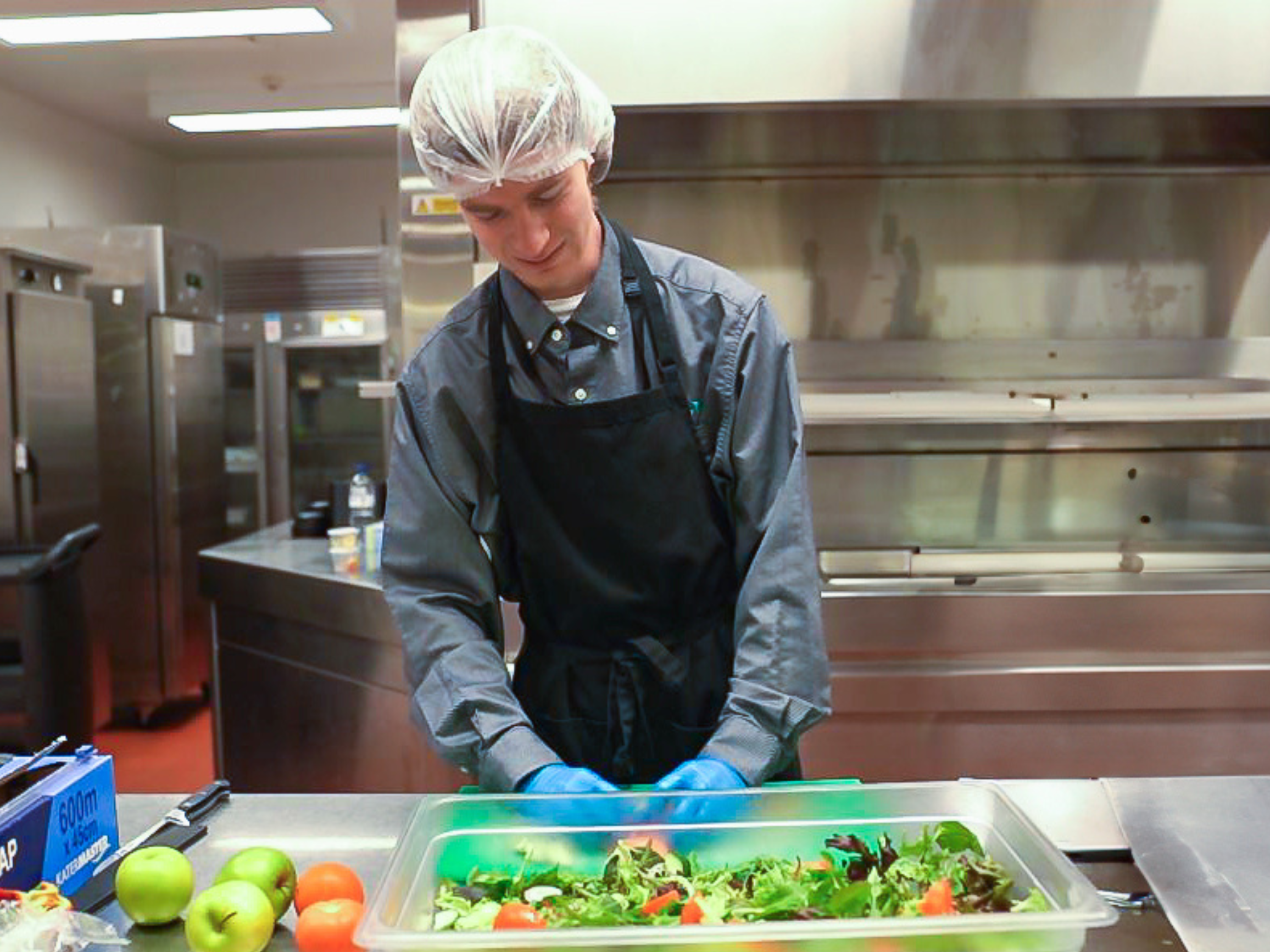 A young man in a kitchen cooking