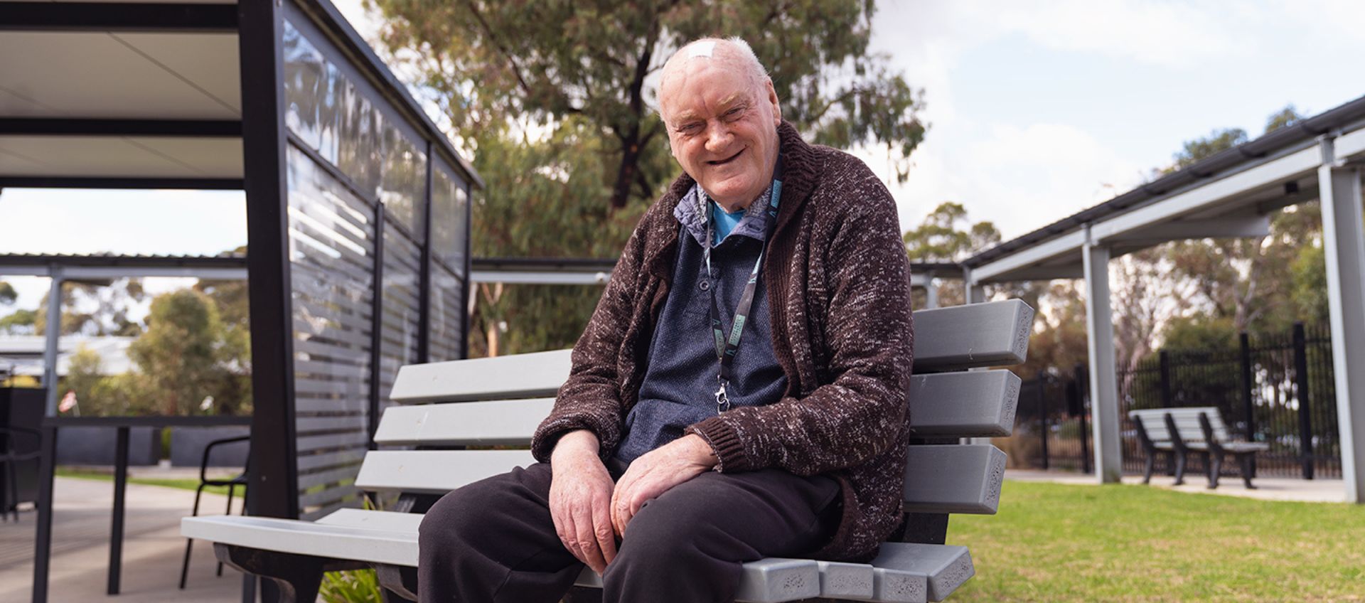 A man sits in a bench outside