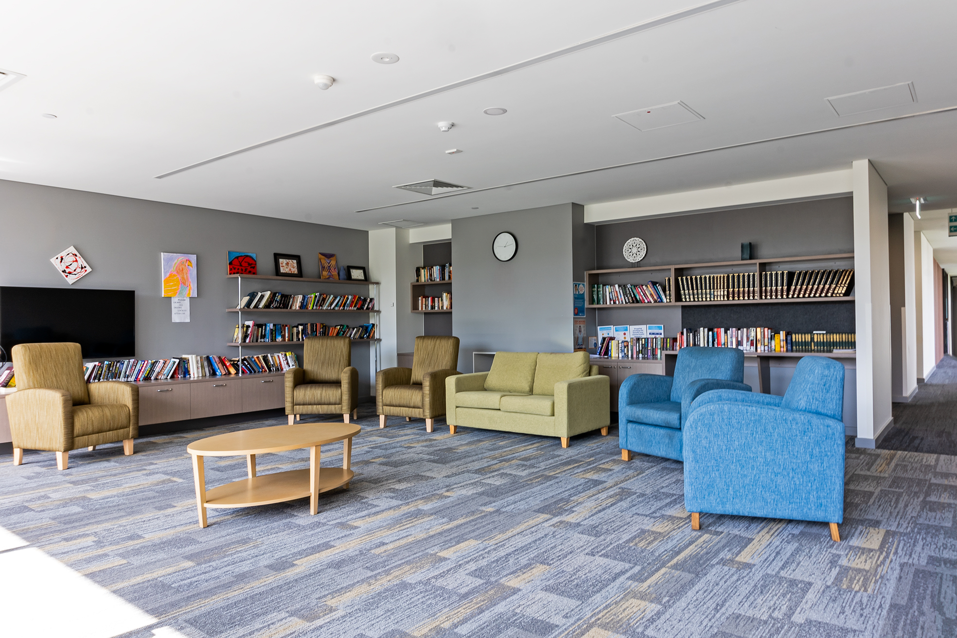 Lounge room with bookshelves and armchairs.