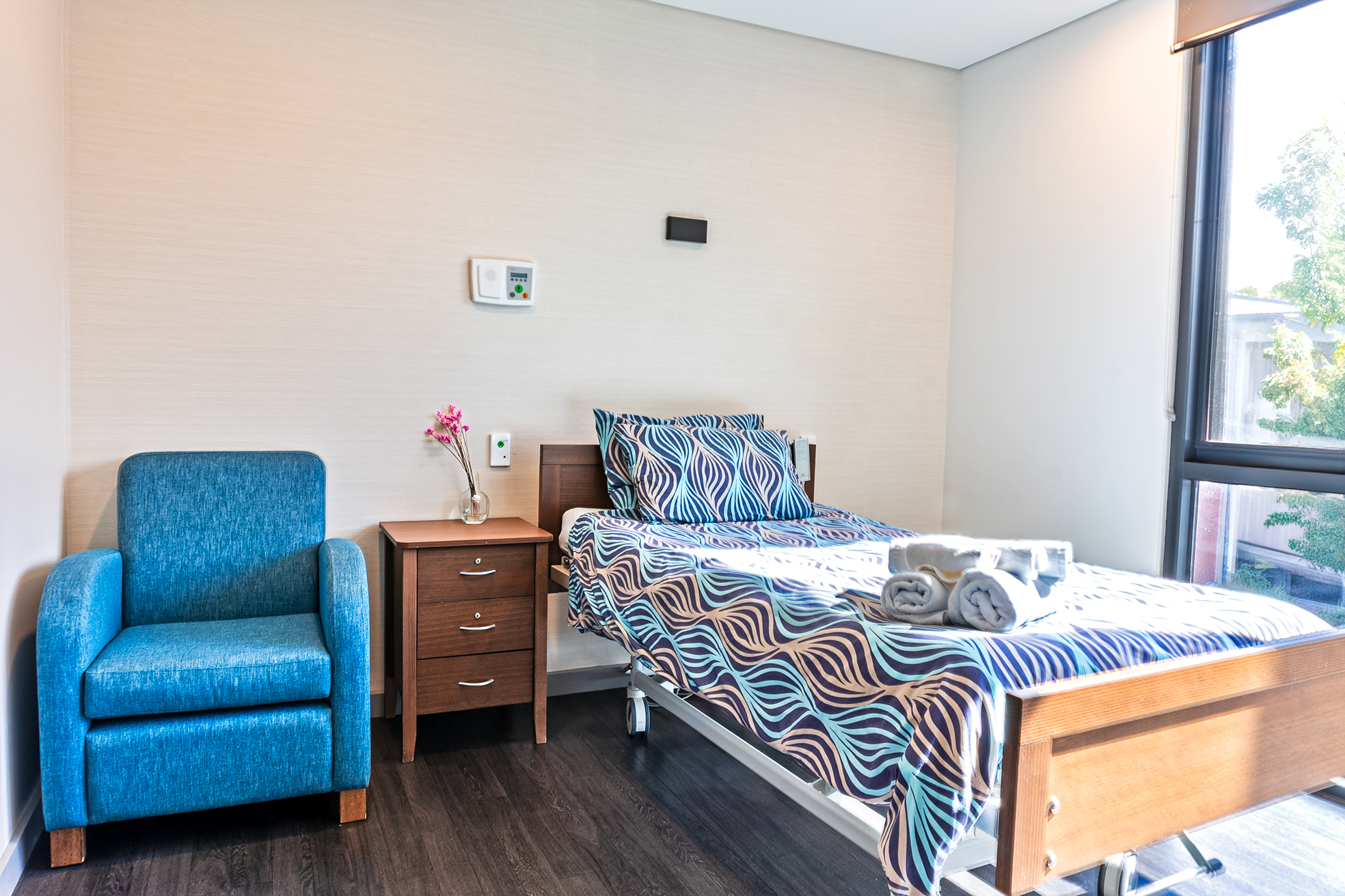 Bedroom with a single sized bed, chair and bedside table.