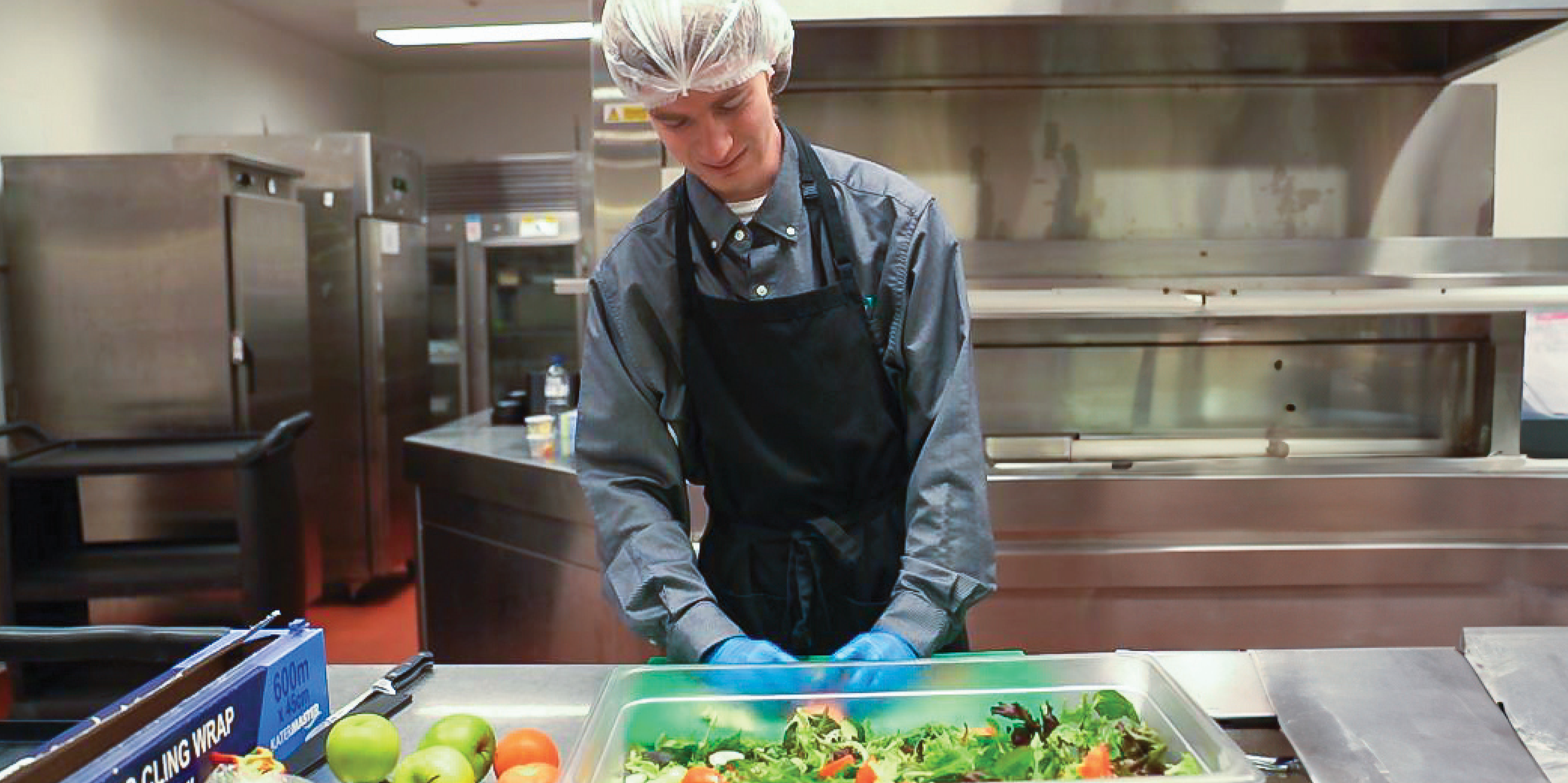 Chef working in kitchen making a salad