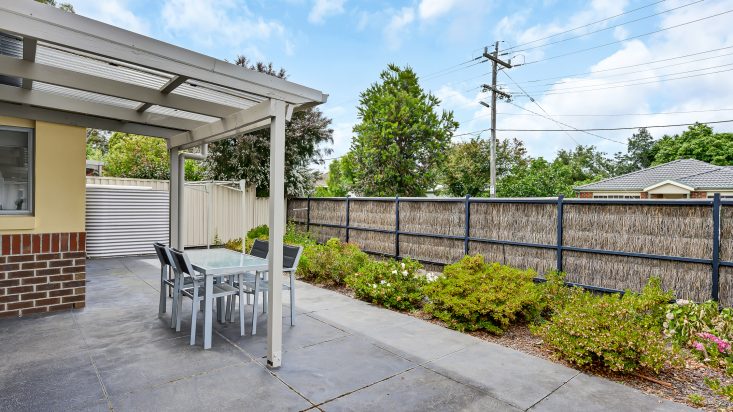 Private courtyard at unit in Corpus Christi Retirement Village, outdoor dining set on shaded patio