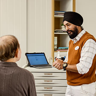 A man is standing, talking to another man who is sitting down