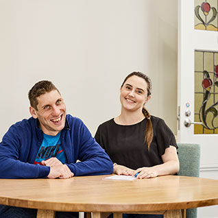 A man and a woman sitting at a table, smiling