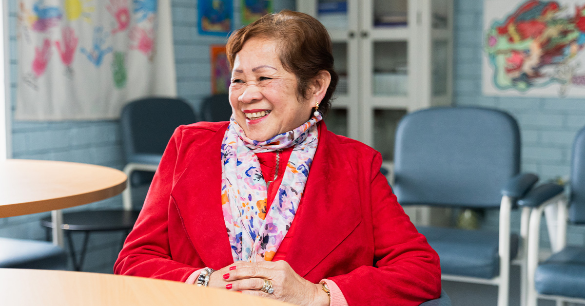 Lyn wearing a red blazer and scarf while at the Filipino Community meet-up.