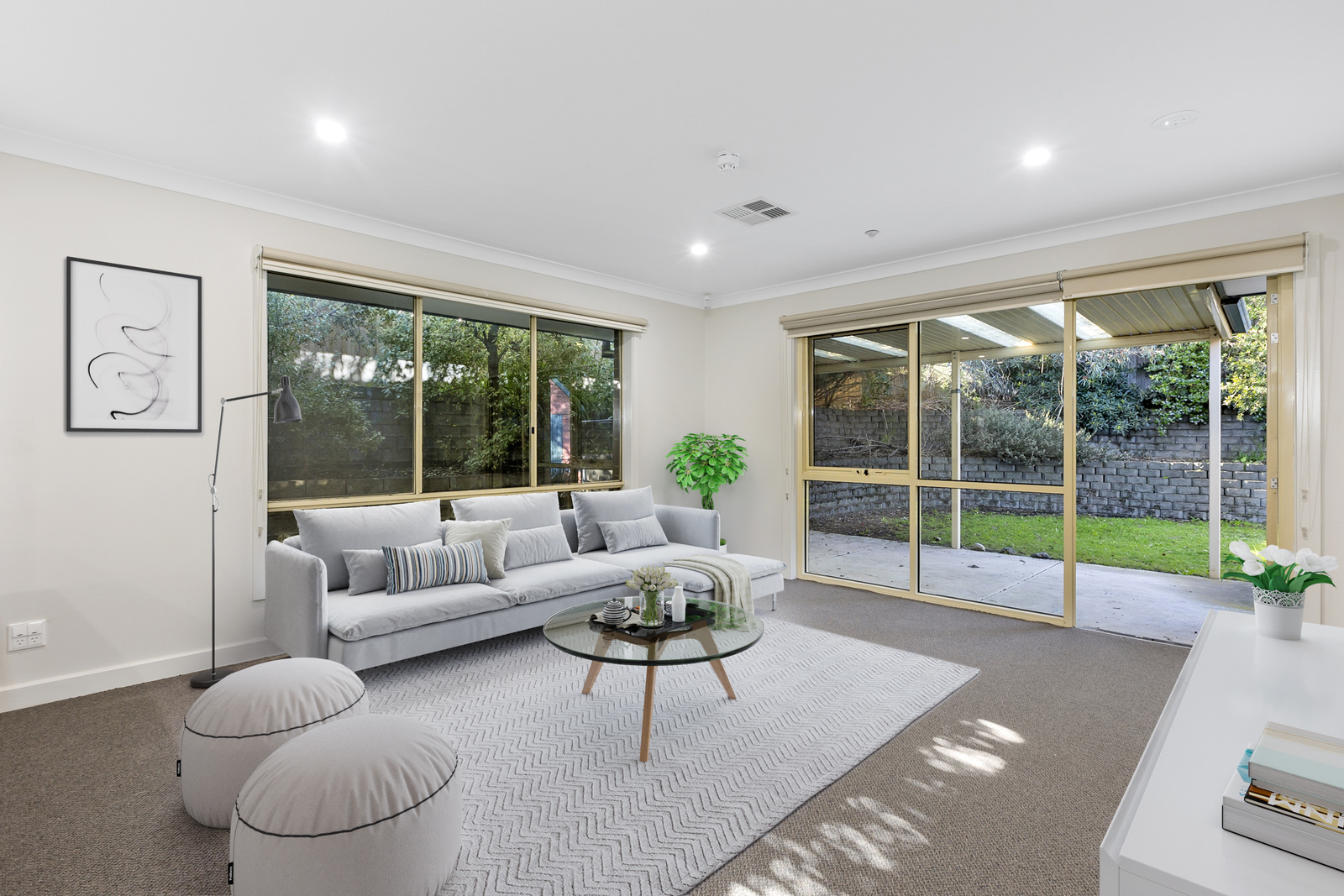 A living room with large windows looking out into the backyard.