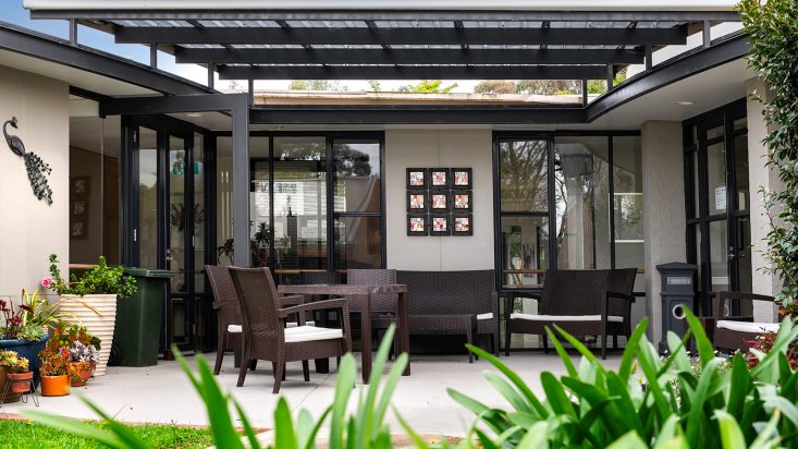 Dark brown patio furniture laid out on an undercover patio.