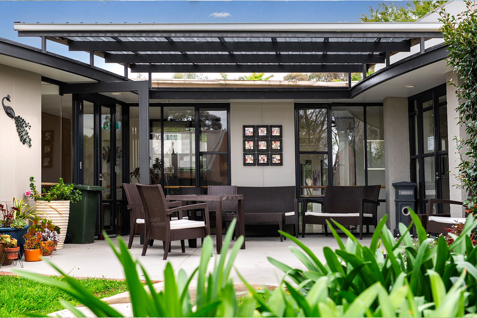 Dark brown patio furniture laid out on an undercover patio.