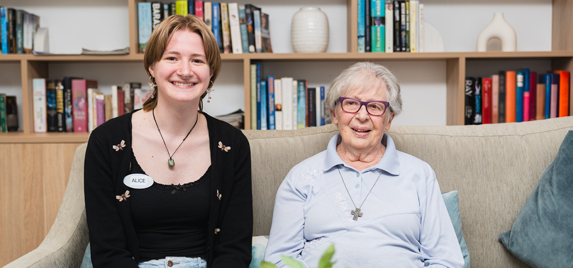 A younger woman and an older woman sit on a couch