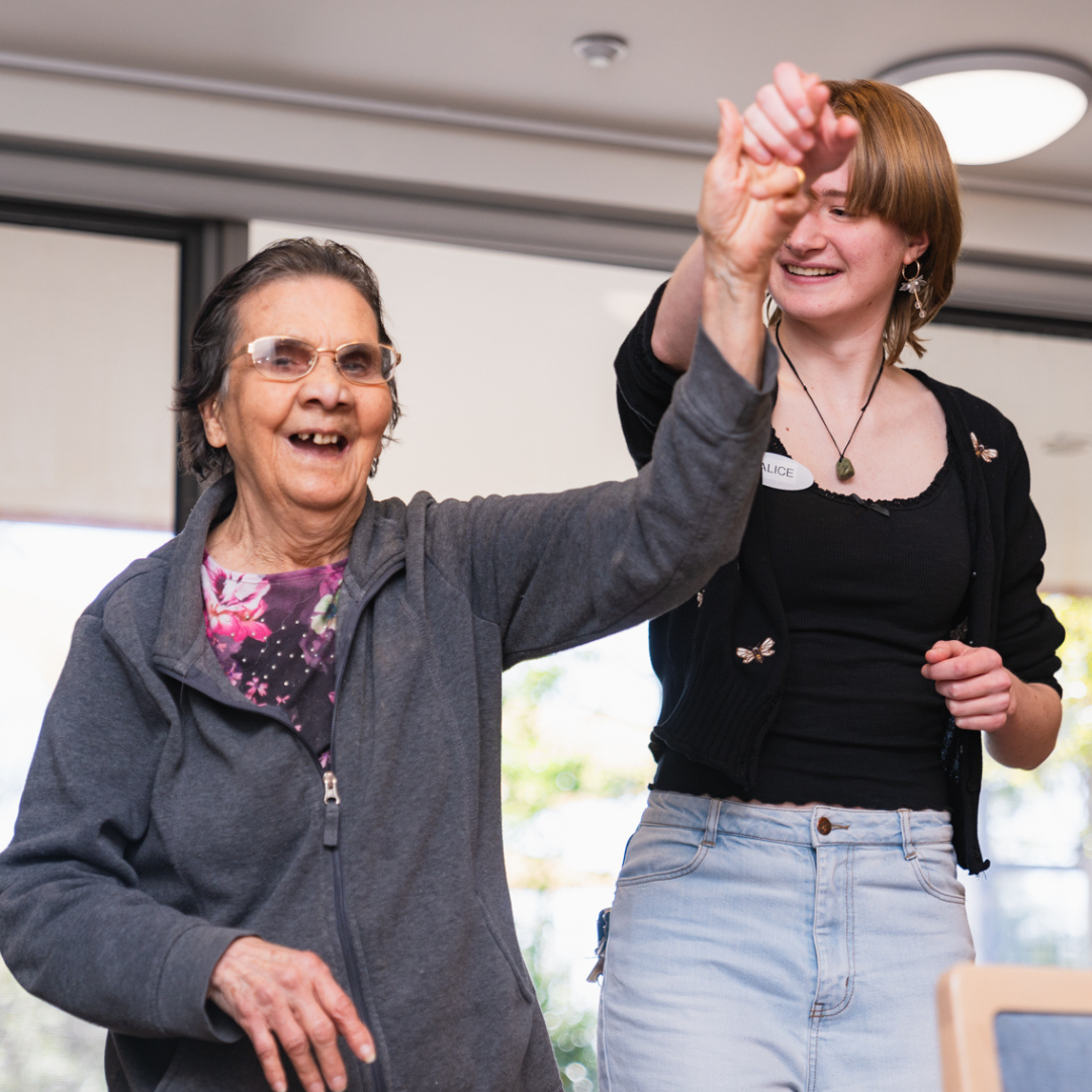 A older woman and a young woman dance