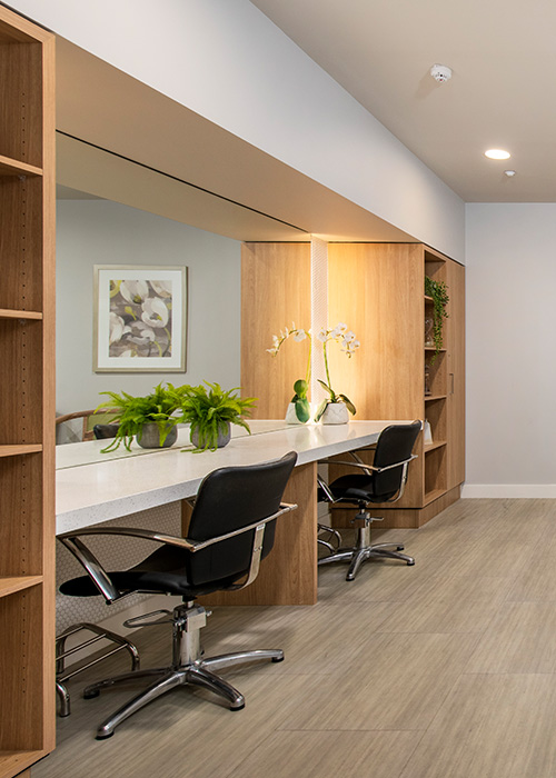 A salon room featuring a white bench and chairs, designed for comfort and style, ideal for consultations and client interactions.