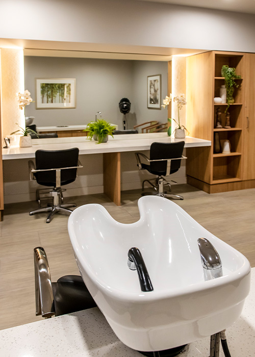 An elegant salon space with a sink and chairs positioned in the center, offering a comfortable setting for hair treatments.