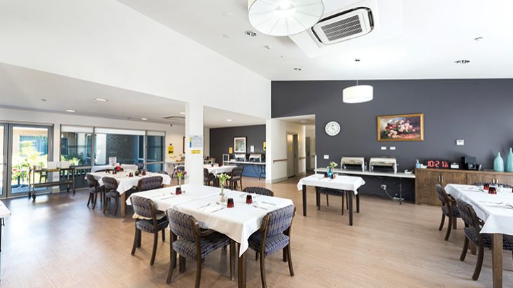 A dining room with multiple tables at Shangolden Aged Care Pakenham.