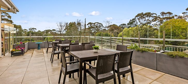 A patio with multiple outdoor tables and chairs.