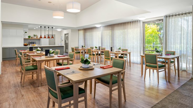 A dining room filled with tables at Corpus Christi Clayton Aged Care.