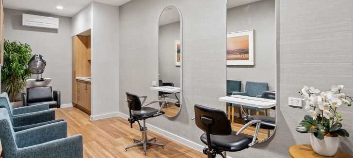 A salon with chairs in front of circular mirrors.