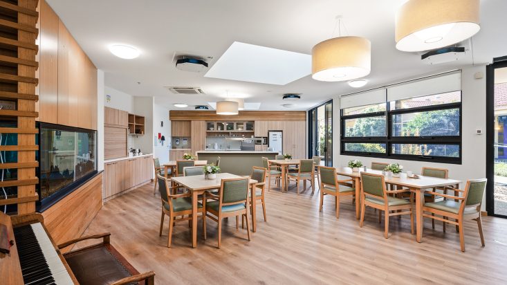 Berwick Aged Care dining room with green chairs at tables across the room.