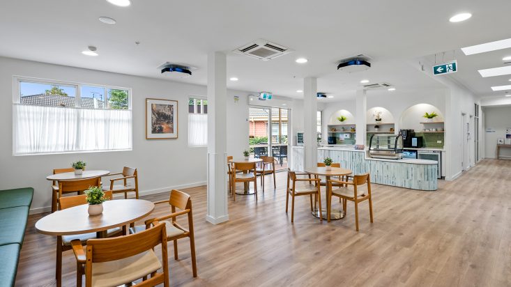 A café with a light blue counter and steel coffee machine at Berwick Aged Care.