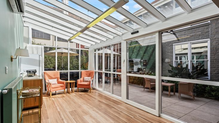 A sun room with windows for walls and a ceiling.