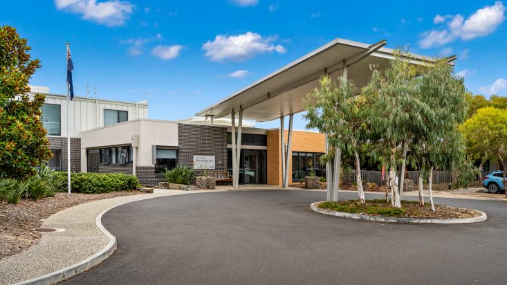 The entrance to a building with a driveway looping around.