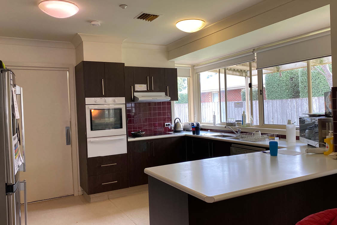 U shaped kitchen with brown cabinets and white oven and rangehood.