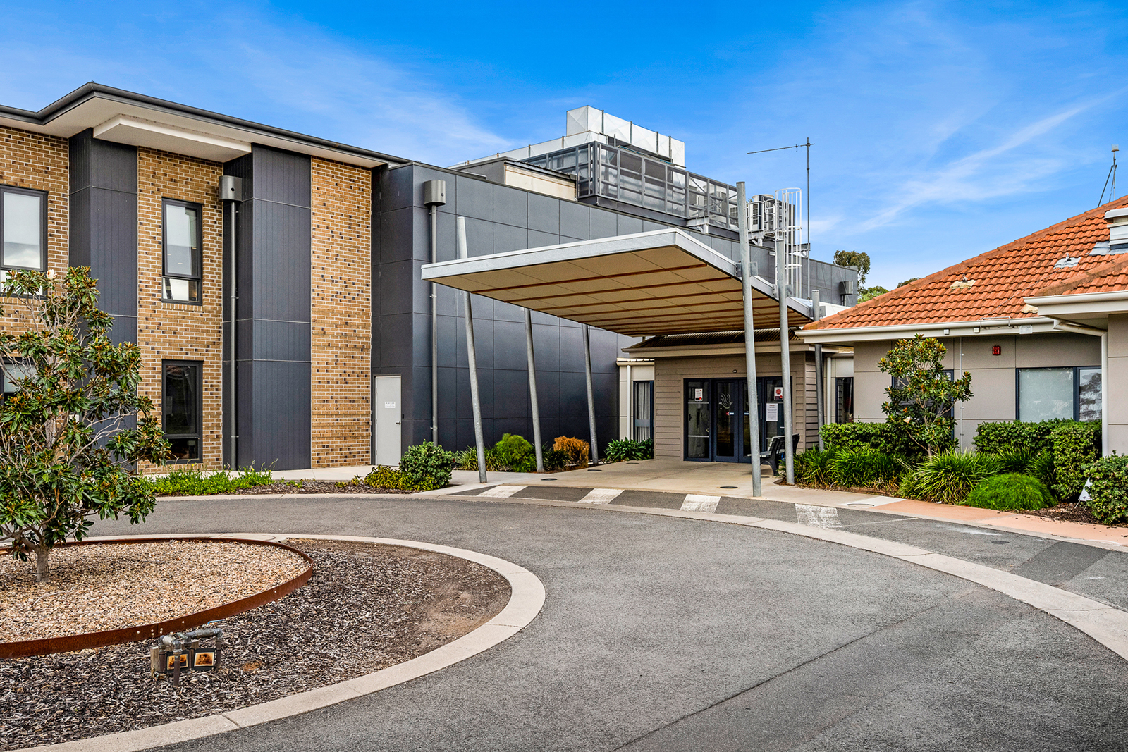 The entrance to a building at the end of a circular driveway.