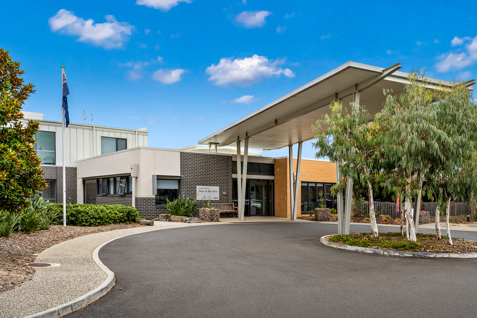 The entrance to a building at the end of a circular driveway.